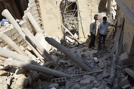 Men inspect a site hit by what activists said was shelling by forces loyal to Syria's President Bashar al-Assad, in the Duma neighbourhood o Men inspect a site hit by what activists said was shelling by forces loyal to Syria's President Bashar al-Assad, in the Duma neighbourhood o
