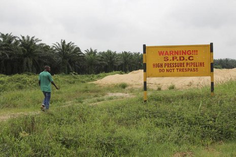 A man walks past a signboard erected along the right of way of Royal Dutch Shell in the Delta region August 6 2013. Reuters/Stringer A man walks past a signboard erected along the right of way of Royal Dutch Shell in the Delta region August 6 2013. Reuters/Stringer
