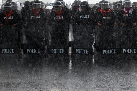 Heavy rain falls on policemen taking positions as rubber farmers protest near the airport in Surat Thani September 4, 2013. REUTERS/Athit Pe Heavy rain falls on policemen taking positions as rubber farmers protest near the airport in Surat Thani September 4, 2013. REUTERS/Athit Pe