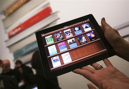 A woman holds up an iPad with the iTunes U app after a news conference introducing a digital textbook service in New York in this January 19 A woman holds up an iPad with the iTunes U app after a news conference introducing a digital textbook service in New York in this January 19