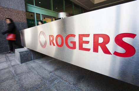 A woman walks by a sign at the Rogers Communications headquarters building on the day of their annual general meeting for shareholders in To A woman walks by a sign at the Rogers Communications headquarters building on the day of their annual general meeting for shareholders in To