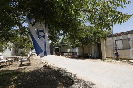 A boy stands near an Israeli flag in the West Bank Jewish settlement of Ofra, north of Ramallah July 18, 2013. REUTERS/Baz Ratner A boy stands near an Israeli flag in the West Bank Jewish settlement of Ofra, north of Ramallah July 18, 2013. REUTERS/Baz Ratner