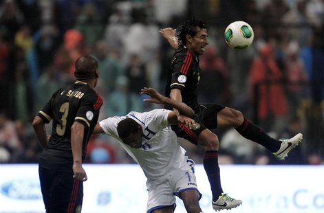 Mexico's Fernando Arce (R) jumps for the ball against Honduras' Jerry Bengston as Mexico's Carlos Salcido looks on during their 2014 World C Mexico's Fernando Arce (R) jumps for the ball against Honduras' Jerry Bengston as Mexico's Carlos Salcido looks on during their 2014 World C