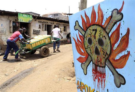 Men push their handcart past a danger sign at the sprawling Kibera slums in Nairobi September 6, 2013. REUTERS/Noor Khamis Men push their handcart past a danger sign at the sprawling Kibera slums in Nairobi September 6, 2013. REUTERS/Noor Khamis