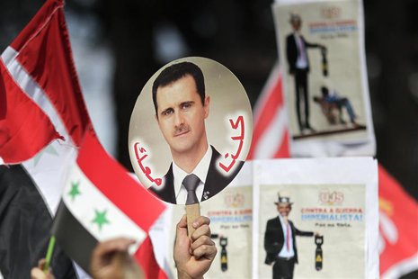 A student holds a sign with a picture of Syria's President Bashar al-Assad during a protest by a students' national union against possible U A student holds a sign with a picture of Syria's President Bashar al-Assad during a protest by a students' national union against possible U