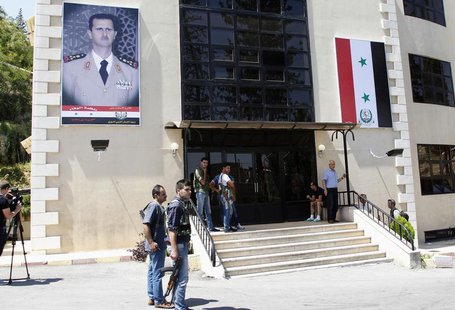 Journalists and security personnel stand in front of Yousef al-Azma military hospital during a visit by team of United Nations chemical weap Journalists and security personnel stand in front of Yousef al-Azma military hospital during a visit by team of United Nations chemical weap