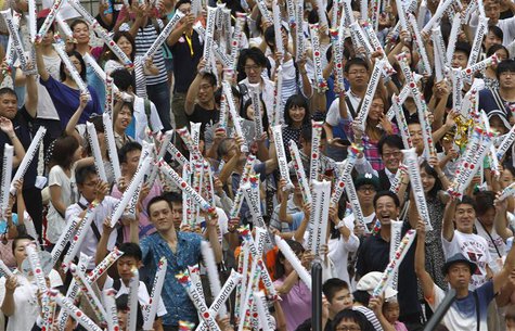 Participants wave inflatable clappers during an event celebrating Tokyo being chosen to host the 2020 Olympic Games, at Tokyo Metropolitan G Participants wave inflatable clappers during an event celebrating Tokyo being chosen to host the 2020 Olympic Games, at Tokyo Metropolitan G
