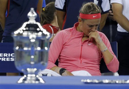 Victoria Azarenka of Belarus wipes her face as she sits by the winner's trophy (L) after being defeated by Serena Williams of the U.S. in th Victoria Azarenka of Belarus wipes her face as she sits by the winner's trophy (L) after being defeated by Serena Williams of the U.S. in th