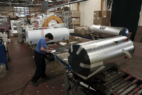 An employee of Calpak company, a Greek company producing and developing solar energy applications, works at the boilers producing line in Ko An employee of Calpak company, a Greek company producing and developing solar energy applications, works at the boilers producing line in Ko