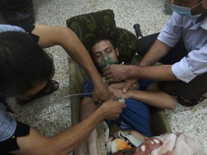 A man, affected by what activists say is nerve gas, breathes through an oxygen mask in the Damascus suburbs of Jesreen August 21, 2013. REUT A man, affected by what activists say is nerve gas, breathes through an oxygen mask in the Damascus suburbs of Jesreen August 21, 2013. REUT