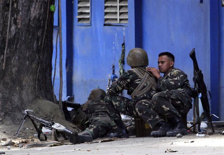 An army sniper aims his rifle at Moro National Liberation Front snipers from behind a tree in Zamboanga, where security forces are battling An army sniper aims his rifle at Moro National Liberation Front snipers from behind a tree in Zamboanga, where security forces are battling