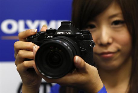 A model poses with Olympus Corp's new OM-D E-M1 digital camera during its unveiling in Tokyo September 10, 2013. REUTERS/Toru Hanai A model poses with Olympus Corp's new OM-D E-M1 digital camera during its unveiling in Tokyo September 10, 2013. REUTERS/Toru Hanai