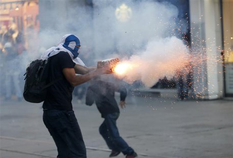 A masked demonstrator uses fireworks against riot police with a home made device during a protest in central Istanbul September 10, 2013. RE A masked demonstrator uses fireworks against riot police with a home made device during a protest in central Istanbul September 10, 2013. RE