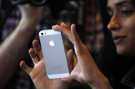 A woman tries the silver colored version of the new iPhone 5S after Apple Inc's media event in Cupertino, California September 10, 2013. REU A woman tries the silver colored version of the new iPhone 5S after Apple Inc's media event in Cupertino, California September 10, 2013. REU