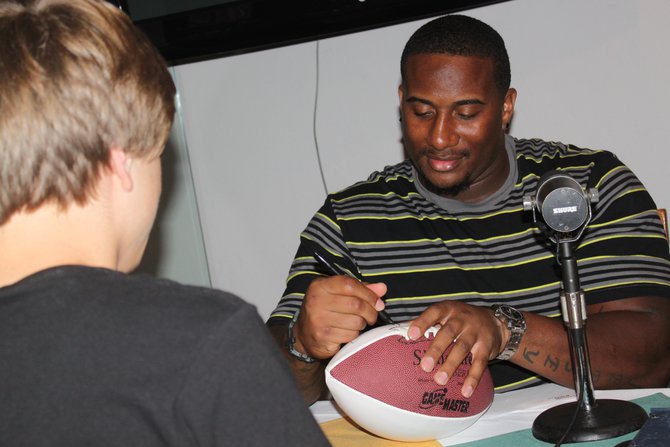 #76 Mike Daniels signs autographs during breaks on the 5th Quarter Show