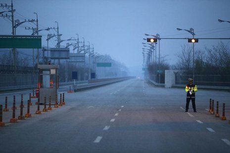 A South Korean police officer stands guard on an empty road connecting the Kaesong Industrial Complex (KIC) inside the North Korean border w A South Korean police officer stands guard on an empty road connecting the Kaesong Industrial Complex (KIC) inside the North Korean border w