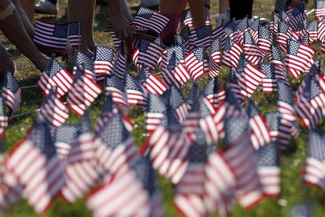 People plant some of the 3000 U.S. flags placed in memory of the lives lost in the September 11, 2001 attacks, at a park in Winnetka, Illino People plant some of the 3000 U.S. flags placed in memory of the lives lost in the September 11, 2001 attacks, at a park in Winnetka, Illino
