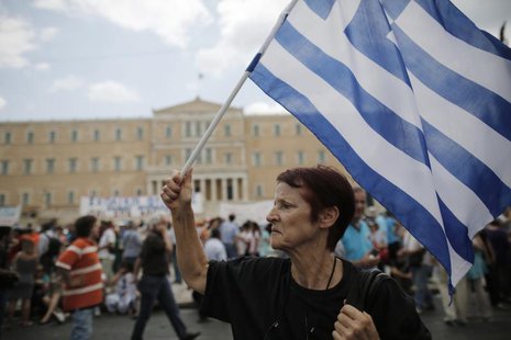 An anti-austerity protester holds a Greek flag during a rally in Athens July, 16, 2013. REUTERS/John Kolesidis An anti-austerity protester holds a Greek flag during a rally in Athens July, 16, 2013. REUTERS/John Kolesidis