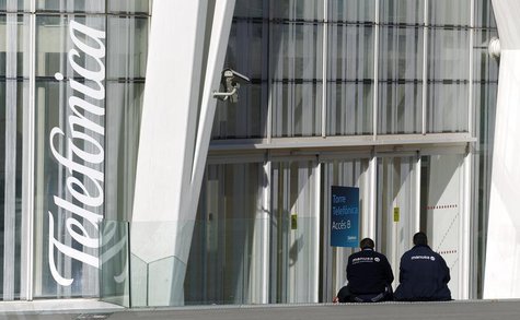 Workers rest sitting next to Telefonica's tower entrance in Barcelona January 30, 2013. REUTERS/Albert Gea Workers rest sitting next to Telefonica's tower entrance in Barcelona January 30, 2013. REUTERS/Albert Gea