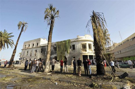 People stand near a Libyan Foreign Ministry building in Benghazi after an explosion in Benghazi September 11, 2013. REUTERS/Esam Omran Al-Fe People stand near a Libyan Foreign Ministry building in Benghazi after an explosion in Benghazi September 11, 2013. REUTERS/Esam Omran Al-Fe