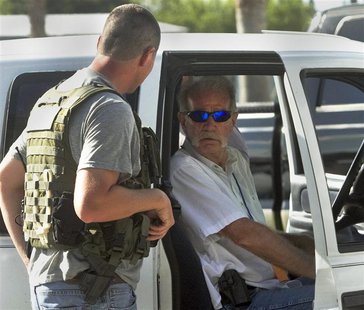 Pastor Terry Jones, (R), talks to a member of the Polk County Sheriff's Department as he sits in his vehicle prior to his arrest after being Pastor Terry Jones, (R), talks to a member of the Polk County Sheriff's Department as he sits in his vehicle prior to his arrest after being
