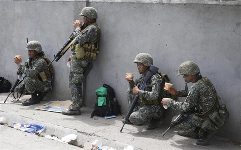 Members of Philippine Marines eat a meal at their positions on the fourth day of a government stand-off with the Moro National Liberation Fr Members of Philippine Marines eat a meal at their positions on the fourth day of a government stand-off with the Moro National Liberation Fr