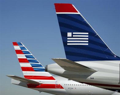 The tail sections of American Airlines (L) and US Airways aircraft are on the ramp at Dallas-Ft Worth International Airport February 14, 201 The tail sections of American Airlines (L) and US Airways aircraft are on the ramp at Dallas-Ft Worth International Airport February 14, 201