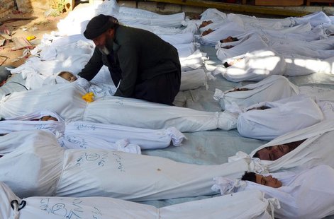 ATTENTION EDITORS - VISUALS COVERAGE OF SCENES OF DEATH AND INJURY A man holds the body of a dead child among bodies of people activists say ATTENTION EDITORS - VISUALS COVERAGE OF SCENES OF DEATH AND INJURY A man holds the body of a dead child among bodies of people activists say