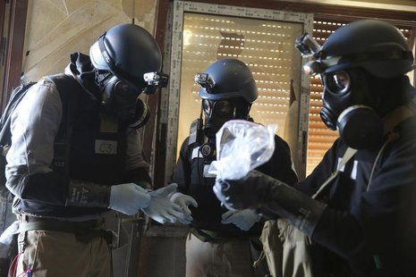 A U.N. chemical weapons expert, wearing a gas mask, holds a plastic bag containing samples from one of the sites of an alleged chemical weap A U.N. chemical weapons expert, wearing a gas mask, holds a plastic bag containing samples from one of the sites of an alleged chemical weap
