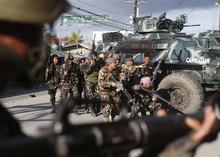 Government soldiers take cover on armoured vehicles as they try to assault the positions of Muslim rebels from the Moro National Liberation Government soldiers take cover on armoured vehicles as they try to assault the positions of Muslim rebels from the Moro National Liberation