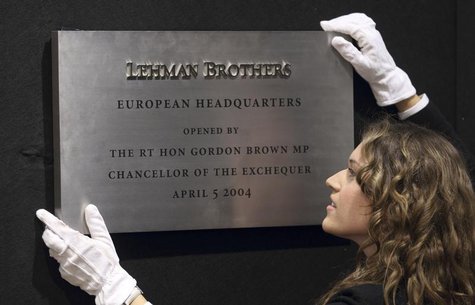 A Christie's employee poses for a photograph with the plaque from Lehman Brothers' European headquarters at Christie's in central London, Se A Christie's employee poses for a photograph with the plaque from Lehman Brothers' European headquarters at Christie's in central London, Se