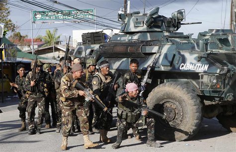 Government soldiers take cover near armoured vehicles as they try to assault the positions of Muslim rebels from the Moro National Liberatio Government soldiers take cover near armoured vehicles as they try to assault the positions of Muslim rebels from the Moro National Liberatio