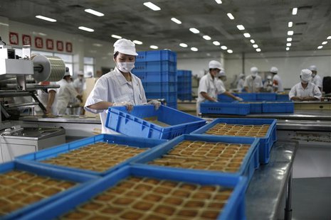 Feshly-baked mooncakes pass along a conveyor belt at a mooncakes factory in Shanghai September 12, 2013. REUTERS/Aly Song Feshly-baked mooncakes pass along a conveyor belt at a mooncakes factory in Shanghai September 12, 2013. REUTERS/Aly Song