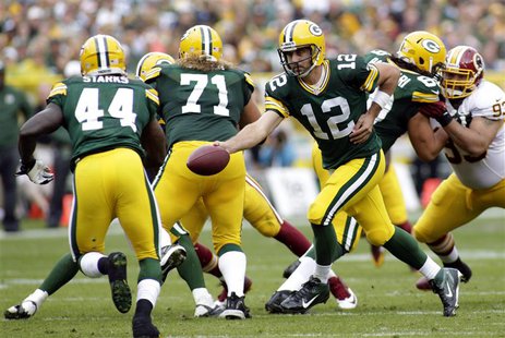 Green Bay Packers quarterback Aaron Rodgers (C) hands off the ball to running back James Starks (L) during the first half of their NFL footb Green Bay Packers quarterback Aaron Rodgers (C) hands off the ball to running back James Starks (L) during the first half of their NFL footb