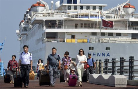 Passengers leave Chinese cruise ship Henna, which is stranded at the port of Jeju on Jeju island, south of Seoul September 15, 2013, to go t Passengers leave Chinese cruise ship Henna, which is stranded at the port of Jeju on Jeju island, south of Seoul September 15, 2013, to go t