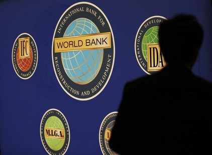 A man is silhouetted against the logo of the World Bank at the main venue for the International Monetary Fund (IMF) and World Bank annual me A man is silhouetted against the logo of the World Bank at the main venue for the International Monetary Fund (IMF) and World Bank annual me