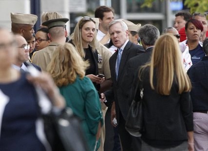U.S. Secretary of the Navy Ray Mabus (C, blue tie) looks on as Navy Yard workers are evacuated after the shooting to a makeshift Red Cross s U.S. Secretary of the Navy Ray Mabus (C, blue tie) looks on as Navy Yard workers are evacuated after the shooting to a makeshift Red Cross s