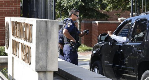 Police officers stop a vehicle to check identification at the main gate of the Washington Navy Yard in Washington, September 17, 2013. REUTE Police officers stop a vehicle to check identification at the main gate of the Washington Navy Yard in Washington, September 17, 2013. REUTE