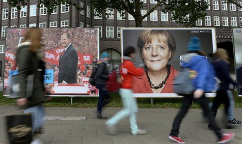 Teenagers pass election posters of Social Democratic top candidate Peer Steinbrueck (SPD) (L) and German Chancellor Angela Merkel (CDU) in H Teenagers pass election posters of Social Democratic top candidate Peer Steinbrueck (SPD) (L) and German Chancellor Angela Merkel (CDU) in H