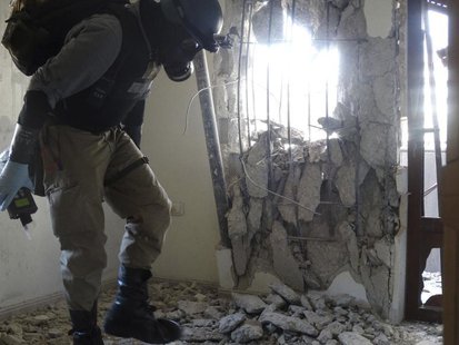 A U.N. chemical weapons expert, wearing a gas mask, inspects one of the sites of an alleged chemical weapons attack in the Damascus' suburb A U.N. chemical weapons expert, wearing a gas mask, inspects one of the sites of an alleged chemical weapons attack in the Damascus' suburb