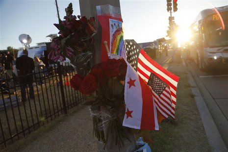 Flowers, flags and a child's drawing are pictured at a makeshift memorial outside the Navy Yard two days after a gunman killed 12 people bef Flowers, flags and a child's drawing are pictured at a makeshift memorial outside the Navy Yard two days after a gunman killed 12 people bef
