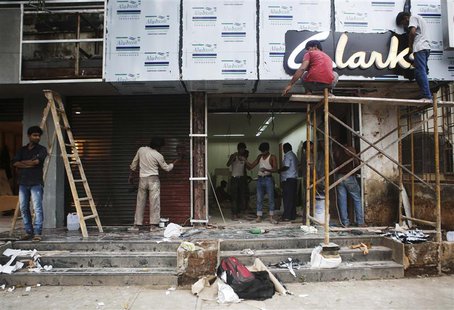 Men work at the site of a new shoe store on a street in Mumbai September 11, 2013. REUTERS/Danish Siddiqui Men work at the site of a new shoe store on a street in Mumbai September 11, 2013. REUTERS/Danish Siddiqui