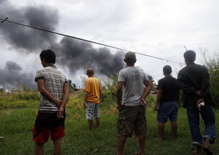 Villagers watch the smoke as fighting rages between government soldiers and the Muslim rebels of the Moro National Liberation Front (MNLF), Villagers watch the smoke as fighting rages between government soldiers and the Muslim rebels of the Moro National Liberation Front (MNLF),