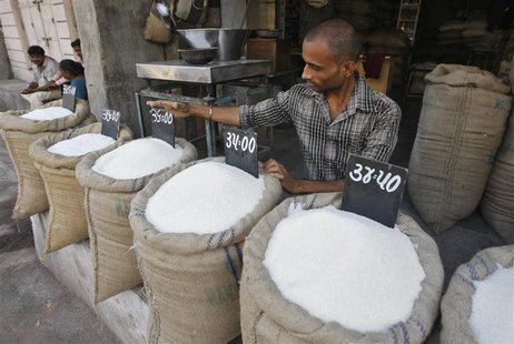 A vendor arranges a price tag over a sack filled with sugar at a wholesale vegetable market in the western Indian city of Ahmedabad Septembe A vendor arranges a price tag over a sack filled with sugar at a wholesale vegetable market in the western Indian city of Ahmedabad Septembe