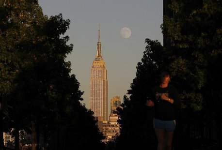 The moon rises at sunset behind New York's Empire State building as a woman runs along a promenade in Hoboken, New Jersey, September 17, 201 The moon rises at sunset behind New York's Empire State building as a woman runs along a promenade in Hoboken, New Jersey, September 17, 201