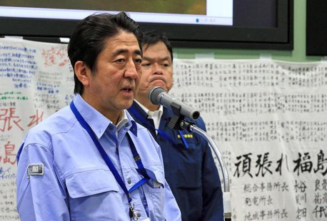 Japan's Prime Minister Shinzo Abe (L) speaks to workers at the emergency operation center during his inspection tour to Tokyo Electric Power Japan's Prime Minister Shinzo Abe (L) speaks to workers at the emergency operation center during his inspection tour to Tokyo Electric Power