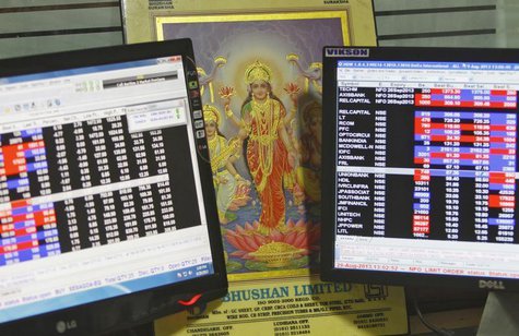 An image of Lakshmi, the Hindu goddess of wealth and prosperity, is placed between monitors displaying share price index at a share trading An image of Lakshmi, the Hindu goddess of wealth and prosperity, is placed between monitors displaying share price index at a share trading