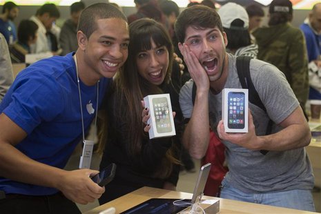 Alejandro de Rosa (R) and Melisa Racineti of Buenos Aires, Argentina pose with their new Apple iPhone 5s phones with Apple employee Jay at t Alejandro de Rosa (R) and Melisa Racineti of Buenos Aires, Argentina pose with their new Apple iPhone 5s phones with Apple employee Jay at t