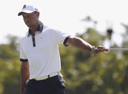 Tiger Woods of the U.S. hands his putter to his caddie after completing play on the ninth green during round two of the Tour Championship go Tiger Woods of the U.S. hands his putter to his caddie after completing play on the ninth green during round two of the Tour Championship go