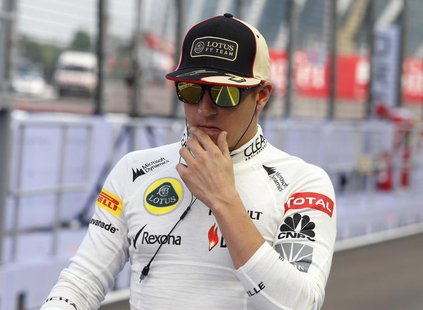 Lotus F1 Formula One driver Kimi Raikkonen of Finland walks in the pit lane during the Singapore F1 Grand Prix at the Marina Bay street circ Lotus F1 Formula One driver Kimi Raikkonen of Finland walks in the pit lane during the Singapore F1 Grand Prix at the Marina Bay street circ